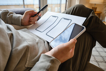 Designer is developing a UX mobile application wireframe. Sketch, prototype, framework, layout future app design for smartphone. UI/UX - user interface and user experience designer. App development