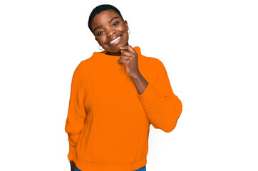 Wall Mural - Young african american woman wearing casual clothes looking confident at the camera with smile with crossed arms and hand raised on chin. thinking positive.