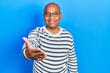 © Krakenimages.com - Middle age latin man wearing casual clothes and glasses smiling friendly offering handshake as greeting and welcoming. successful business.