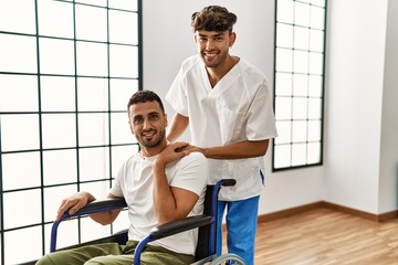 Sticker - Two hispanic men physiotherapist and patient sitting on wheelchair having rehab session at clinic