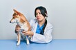 © Krakenimages.com - Beautiful hispanic veterinarian woman checking dog health depressed and worry for distress, crying angry and afraid. sad expression.