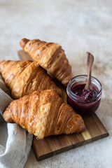 Wall Mural - Fresh crispy croissants with jam, concrete background. Homemade bakery for tasty breakfast.