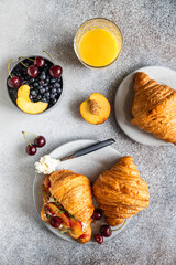 Wall Mural - Croissant sandwiches with nectarine, cherry and ricotta or cream cheese in a plate with orange juice for tasty breakfast. Top view.