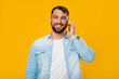 © Prostock-studio - Smiling adult european man talking on phone with client or friend, isolated on yellow background
