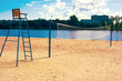 © NikLemesh - A stretched volleyball net on a sandy sports field near the river on a sunny summer day