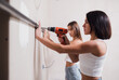 © kalinichenkod - young women make repairs in the apartment. Two girls make repairs at home on their own