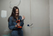 © kalinichenkod - young beautiful woman makes repairs in the apartment. the girl makes repairs at home on her own paints the walls
