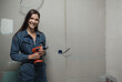 © kalinichenkod - young beautiful woman makes repairs in the apartment. the girl makes repairs at home on her own paints the walls