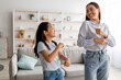 © Prostock-studio - Excited asian mom and cute daughter dancing to music and having fun at home, smiling to each other