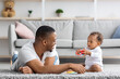 Shared Parental Leave. Young Black Father Playing With Little Baby At Home