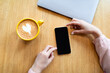 © Prostock-studio - Cool app. Lady using smartphone with empty screen and drinking coffee at cafe, top view, mockup