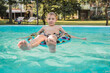 © ADDICTIVE STOCK - Boy enjoying summer day on while floating in pool on inflatable ring