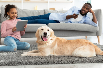 Wall Mural - Black family spending time together at home with dog