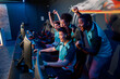 © Yaroslav Astakhov - Multiracial team of happy professional cyber sports gamers celebrating success wile raising hands up during esports tournament in gaming club