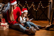 © Prostock-studio - Portrait of cute girl writing letter to Santa with mom