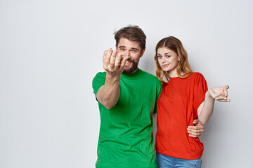 Wall Mural - a young couple multicolored t-shirts communication quarrel isolated background