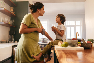 happy mother and son smiling at each other in the kitchen