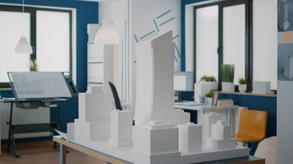 Poster - Close up of building model on table to design construction layout in architectural office. Maquette plan to create real estate property and urban development with project in empty space.