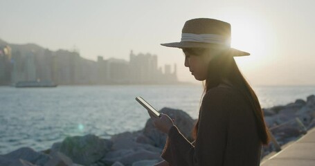 Poster - Woman use of mobile phone under sunset