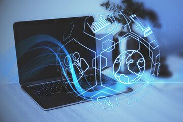 Poster - Close up of workplace with laptop and creative blue spherical business interface on blurry background. Technology, finance and innovation. Double exposure.