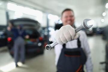 Wall Mural - Car maintenance service worker holding wrench equipment for work