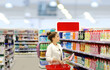 © lado2016 - Woman shopping in supermarket reading product information.woman choosing laundry detergent in supermarket