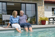 © goodluz - Middle-aged couple enjoying time by private pool