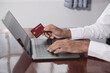 © Orathai - The businessman's hand is holding a credit card and using a laptop for online shopping and internet payment
