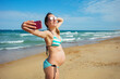 © Sergey Novikov - Pregnant woman on vacations take selfie at beach