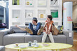 © Westend61 - Cheerful couple sitting on sofa in furniture store