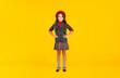 © be free - positive child in school uniform and beret full length on yellow background, pupil