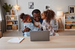 © Seventyfour - Portrait of two children kissing African-American father working from home, copy space