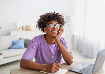 Poster - Home schooling, online education. Black teen sitting at desk with laptop, studying remotely, taking notes during class