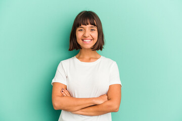 Young mixed race woman isolated on blue Young mixed race woman isolated on blue background who feels confident, crossing arms with determination.