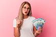 © Asier - Young russian woman holding bills isolated on pink background having some great idea, concept of creativity.