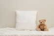 © IndrePau - White square baby pillow mockup for design presentation, blank canvas nursery cushion, blanket and soft toy bear.