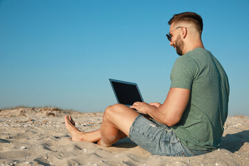 Sticker - Man working with modern laptop on beach