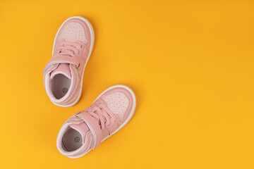 Pink child shoes on yellow background. Children's shoes for girls