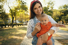 Portrait Of Young Mother With Her Cute Baby In Park On Sunny Day