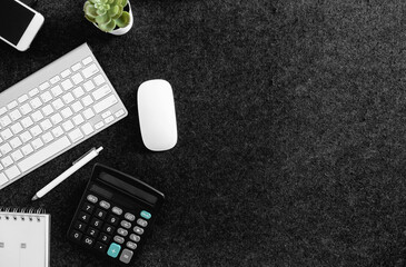 Poster - top view of office desk table with  calculator, notebook, plastic plant, smartphone and keyboard.