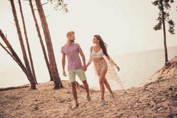 Wall Mural - Photo of carefree cheerful couple lovers hold hands go sand wear casual outfit nature seaside beach outdoors