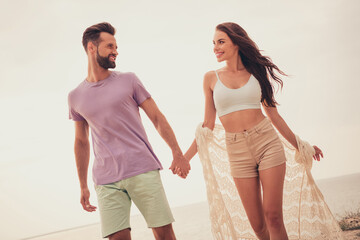 Poster - Photo of carefree pretty young lovers dressed casual outfits smiling walking holding arms outdoors countryside