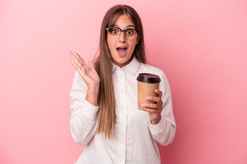 Wall Mural - Young business caucasian woman holding a take away isolated on pink background surprised and shocked.