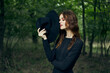 © VICHIZH - woman in the forest in a black hat gothic style Witch costume