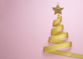 Wall Mural - christmas tree shape golden ribbon on pink background. shiny star on top. merry xmas card