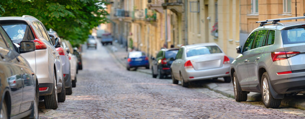 Naklejka na meble City traffic with cars parked in line on street side.