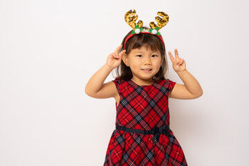 Wall Mural - Beautiful little asian girl in santa hat showing peace symbol isolated over white background.