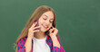 © Olena - happy kid speaking on smartphone in classroom at blackboard, copy space, conversation