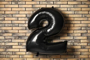 Inflatable balloon in shape of figure 2 on brick background