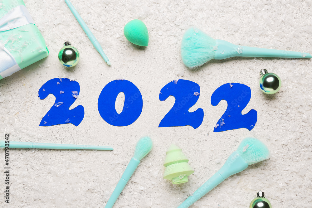 Figure 2022 with makeup supplies and snow on white background